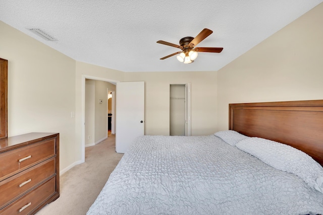 carpeted bedroom featuring ceiling fan, a closet, and a textured ceiling