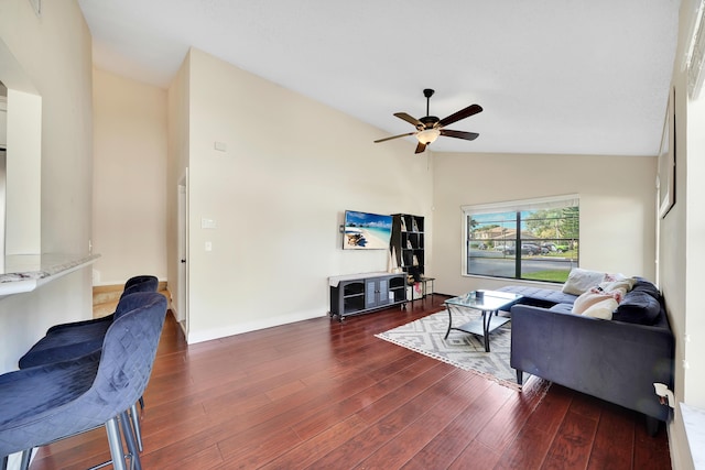 living room with dark hardwood / wood-style floors, ceiling fan, and vaulted ceiling