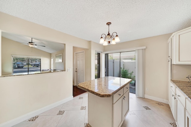 kitchen featuring a center island, pendant lighting, lofted ceiling, a textured ceiling, and ceiling fan with notable chandelier