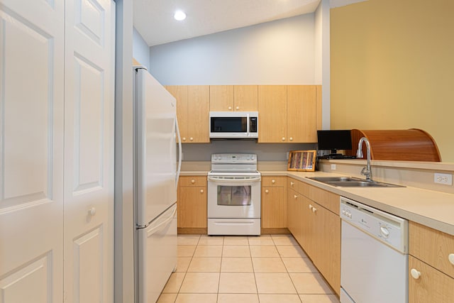 kitchen featuring light brown cabinets, white appliances, vaulted ceiling, and sink