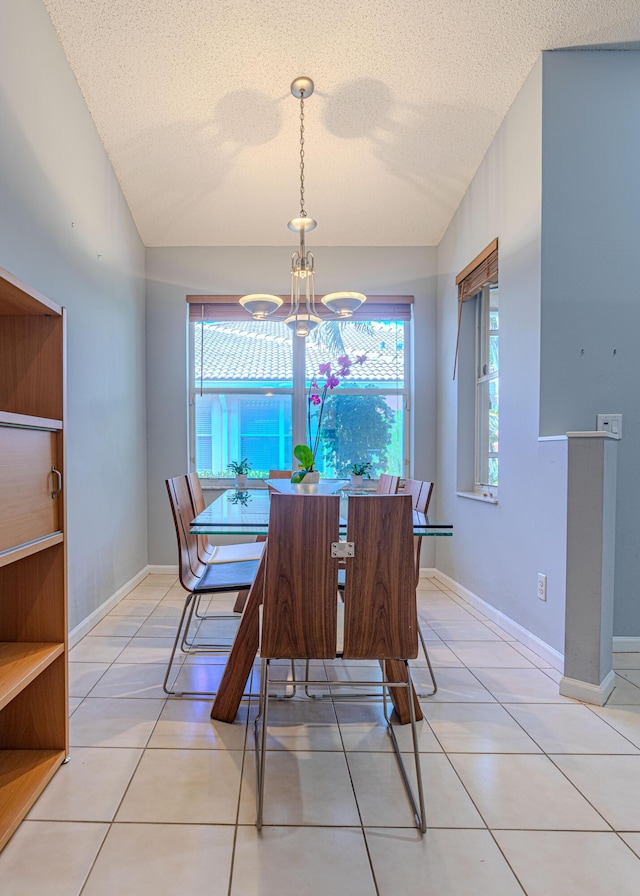 tiled dining room featuring lofted ceiling and a textured ceiling