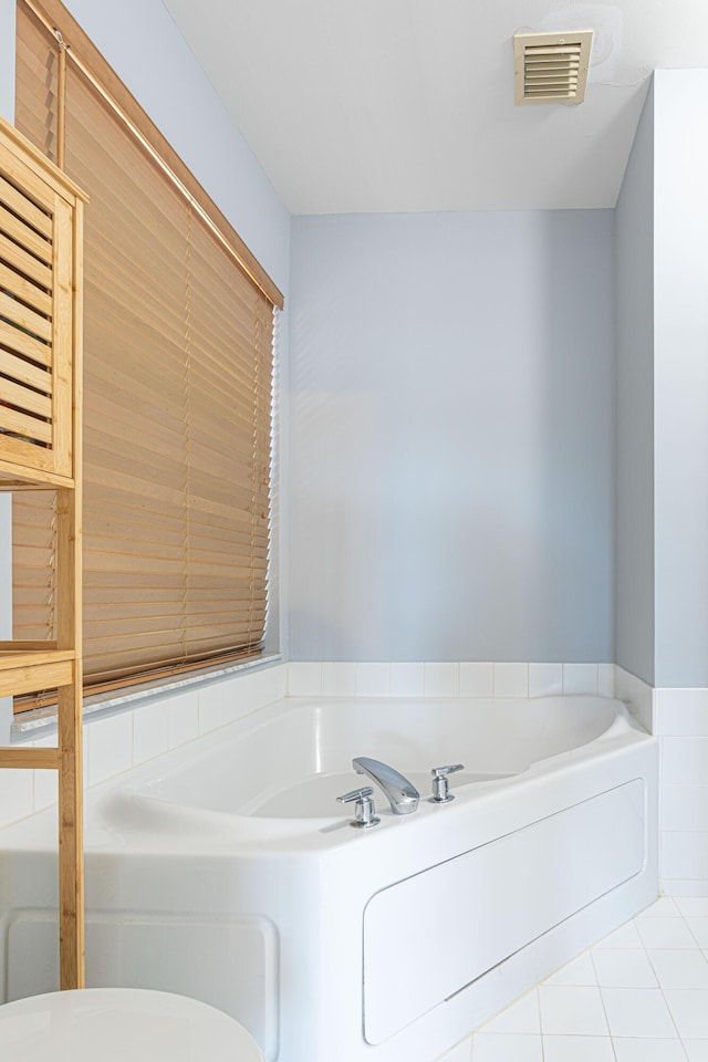 bathroom with tile patterned flooring, toilet, and a bathing tub