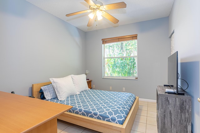 tiled bedroom featuring ceiling fan and a textured ceiling