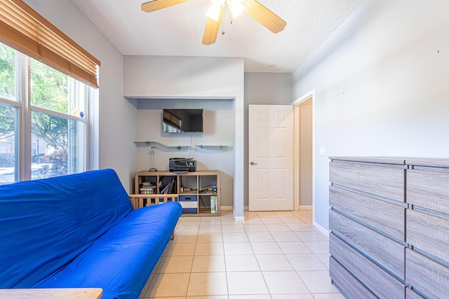 tiled living room featuring ceiling fan and a textured ceiling