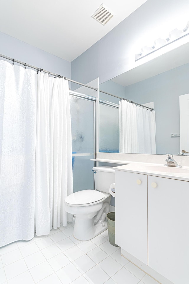 bathroom featuring toilet, tile patterned flooring, vanity, and walk in shower