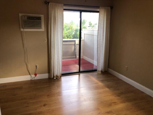 spare room with hardwood / wood-style flooring and a wall mounted air conditioner