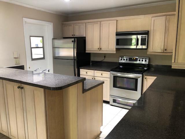 kitchen featuring light brown cabinets, crown molding, and appliances with stainless steel finishes