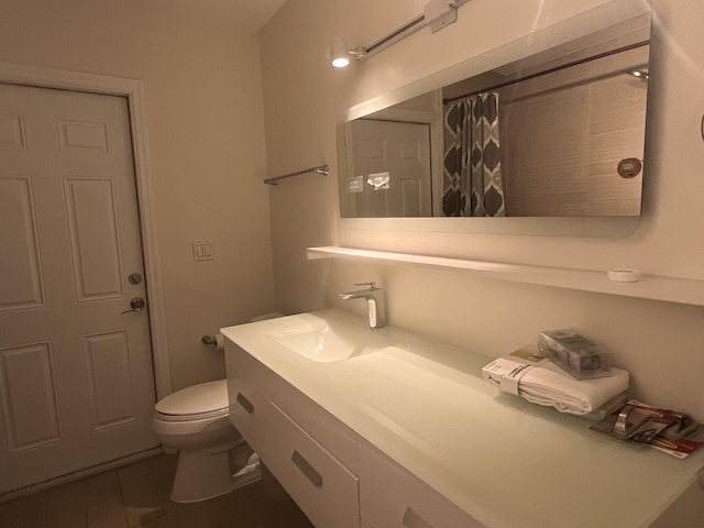 bathroom featuring vanity, toilet, and walk in shower