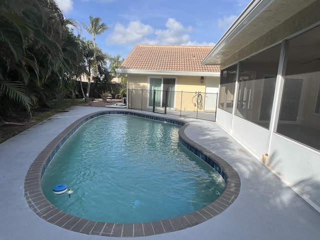 view of swimming pool with a patio and a sunroom