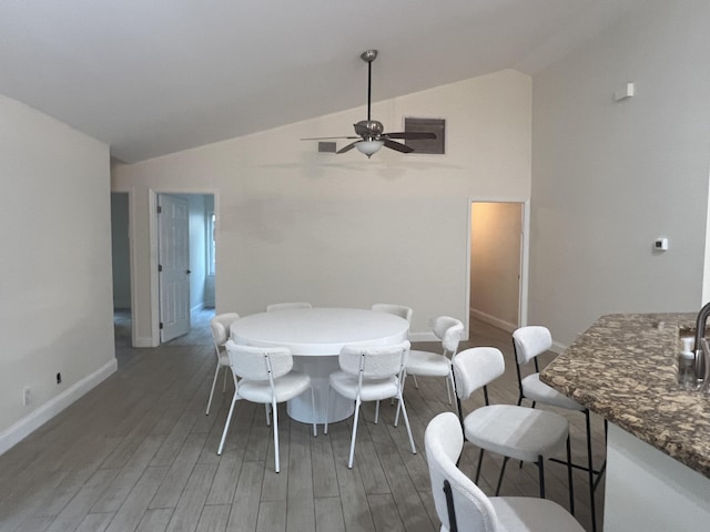 dining area featuring vaulted ceiling, ceiling fan, and dark hardwood / wood-style floors