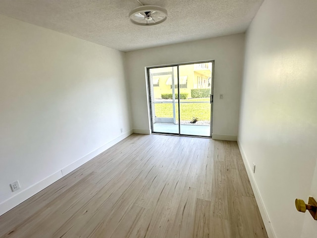 empty room with a textured ceiling, light hardwood / wood-style floors, and ceiling fan