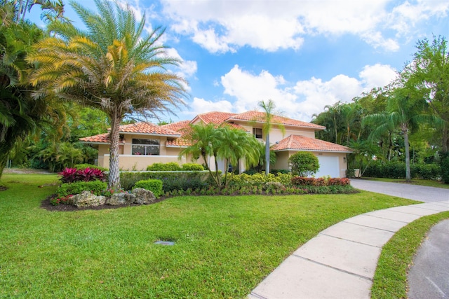 mediterranean / spanish-style home with a garage and a front lawn