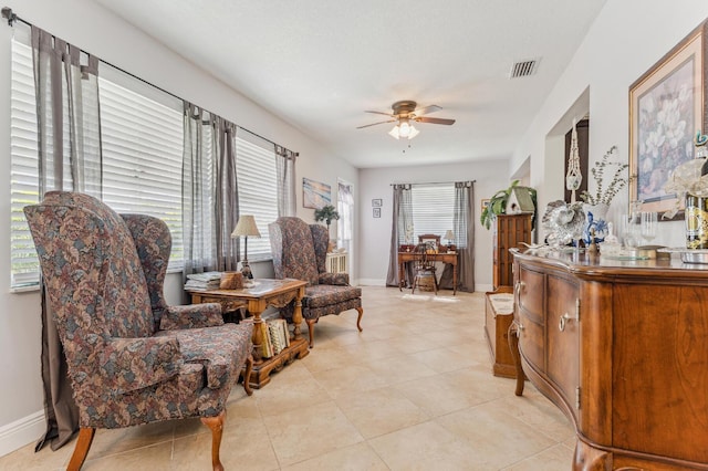 sitting room featuring ceiling fan, light tile patterned floors, and a wealth of natural light