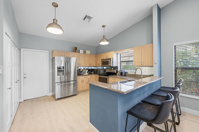 kitchen featuring a wealth of natural light, light brown cabinetry, and stainless steel appliances