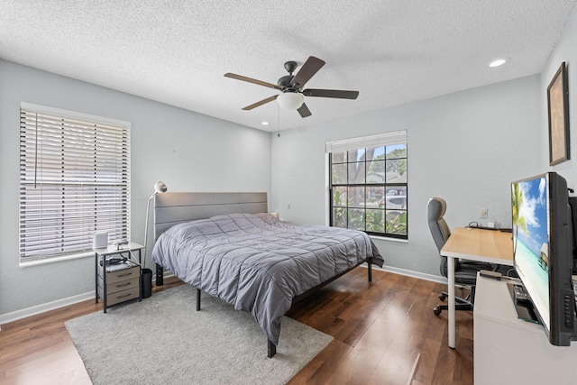 bedroom with a textured ceiling, ceiling fan, and dark wood-type flooring