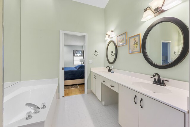 bathroom with tile patterned flooring, vanity, and a washtub