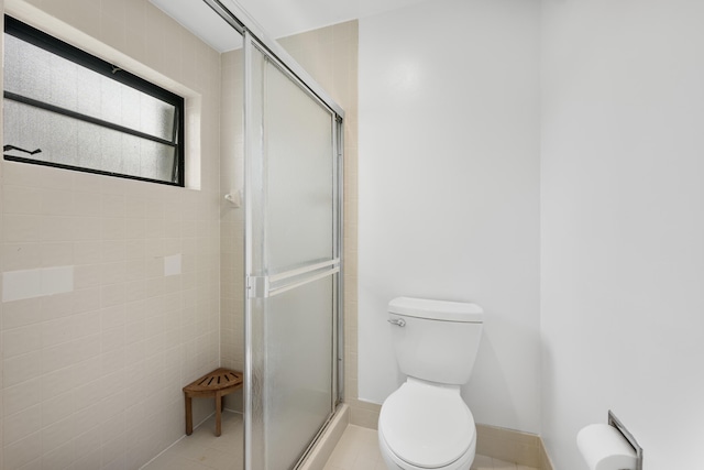 bathroom featuring toilet, tile patterned floors, and walk in shower