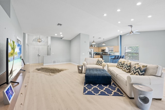 living room featuring ceiling fan, light hardwood / wood-style floors, and lofted ceiling