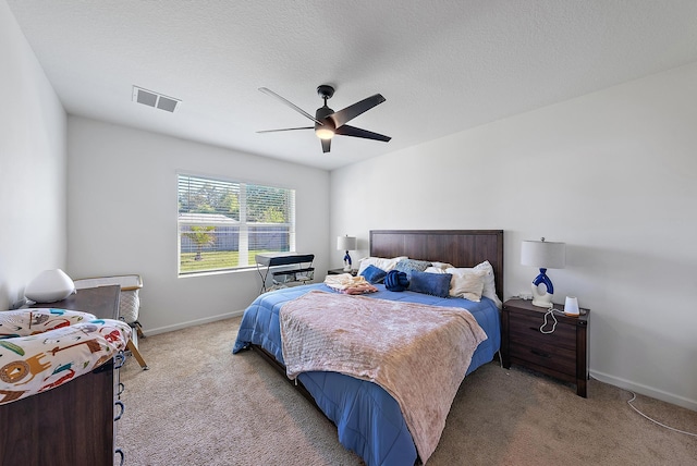 bedroom featuring ceiling fan, carpet floors, and a textured ceiling