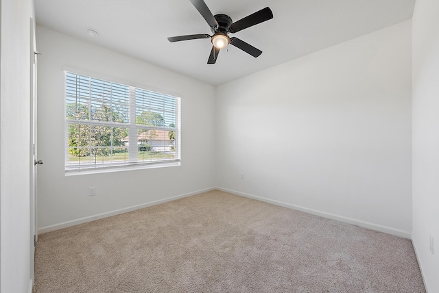 carpeted spare room with ceiling fan