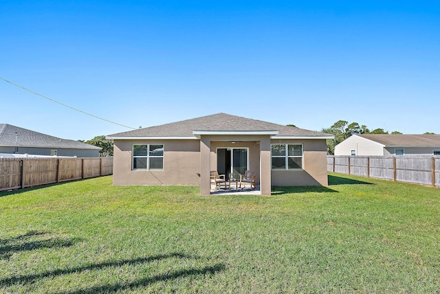 rear view of property featuring a yard and a patio