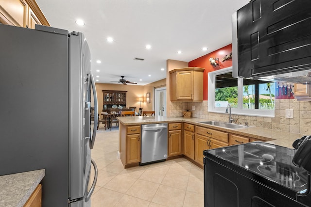 kitchen featuring sink, ceiling fan, decorative backsplash, appliances with stainless steel finishes, and kitchen peninsula