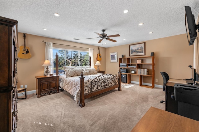 bedroom with ceiling fan, light carpet, and a textured ceiling