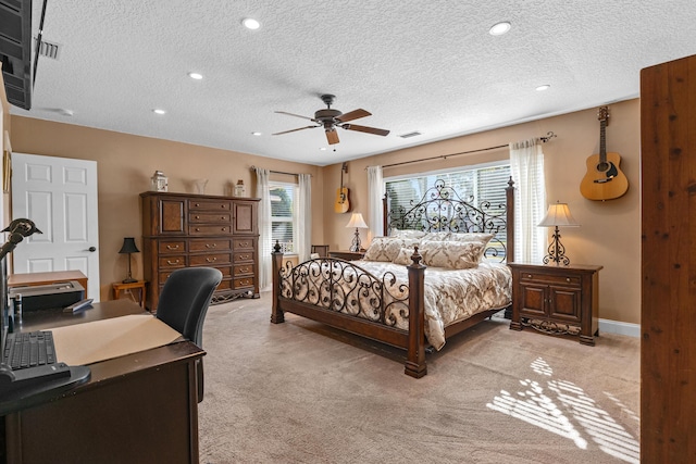 bedroom featuring a textured ceiling, ceiling fan, and light carpet