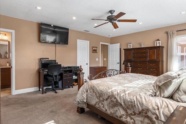 bedroom with connected bathroom, ceiling fan, light carpet, and a textured ceiling