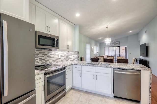 kitchen featuring kitchen peninsula, appliances with stainless steel finishes, white cabinetry, and sink