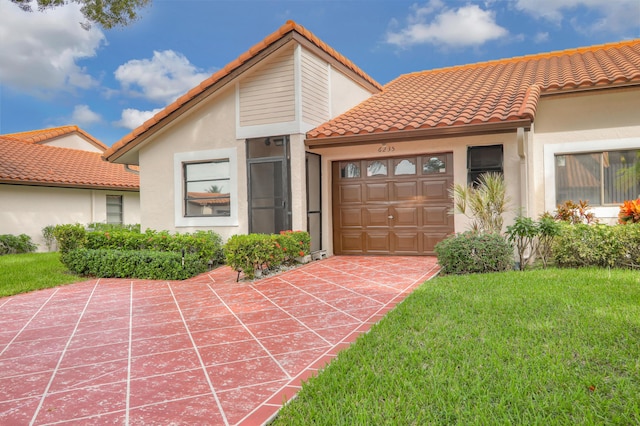 mediterranean / spanish-style home with a front lawn and a garage