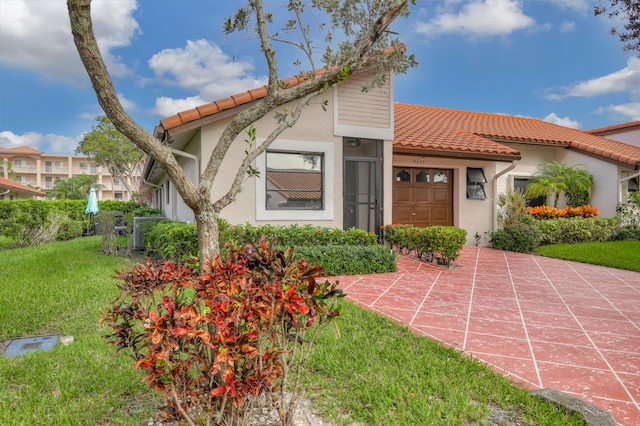 mediterranean / spanish-style home with a garage and a front lawn