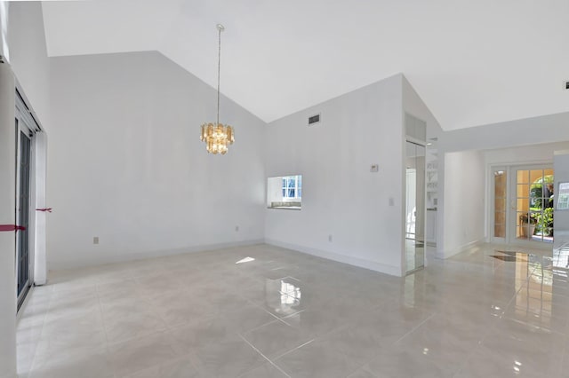 empty room featuring a notable chandelier, light tile patterned flooring, high vaulted ceiling, and french doors