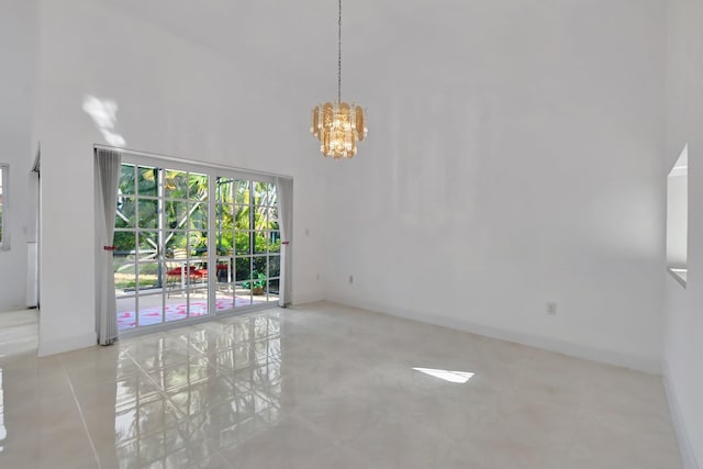 unfurnished dining area featuring a towering ceiling, light tile patterned floors, and a notable chandelier