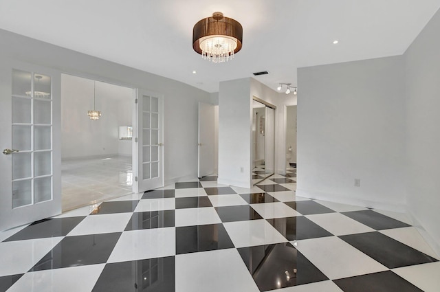 tiled spare room with french doors and a chandelier