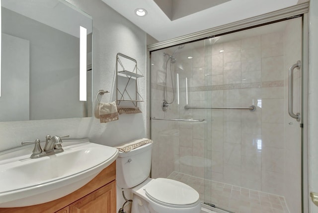 bathroom featuring toilet, vanity, and walk in shower