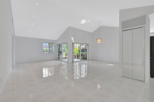 unfurnished living room featuring high vaulted ceiling and light tile patterned floors