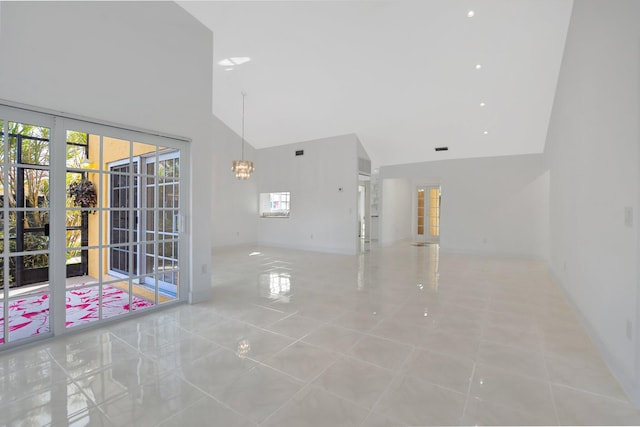 tiled empty room with high vaulted ceiling and a notable chandelier