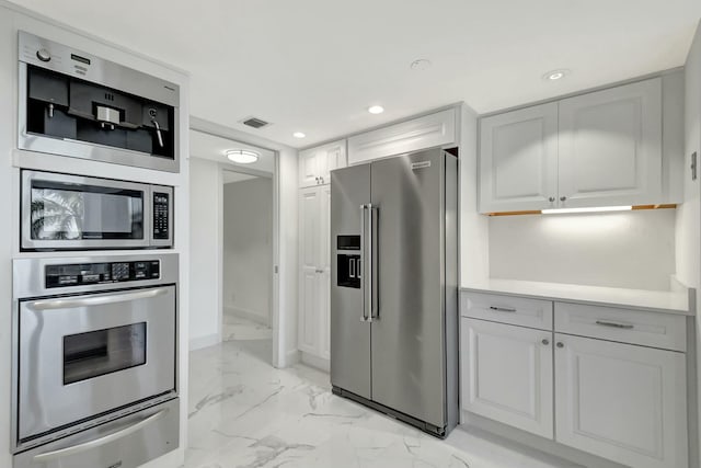 kitchen featuring marble finish floor, stainless steel appliances, light countertops, a warming drawer, and recessed lighting