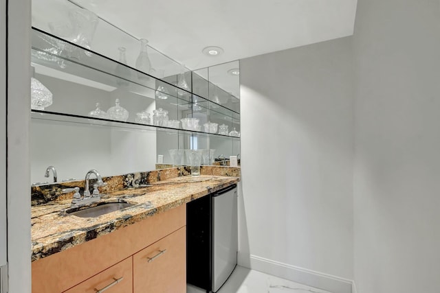 bar featuring marble finish floor, indoor wet bar, a sink, dishwasher, and baseboards