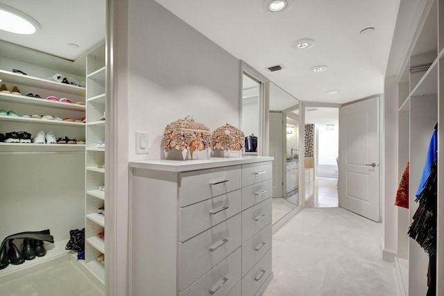 spacious closet featuring visible vents and light colored carpet