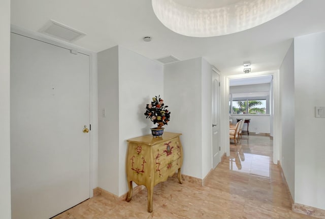 hallway featuring visible vents and attic access