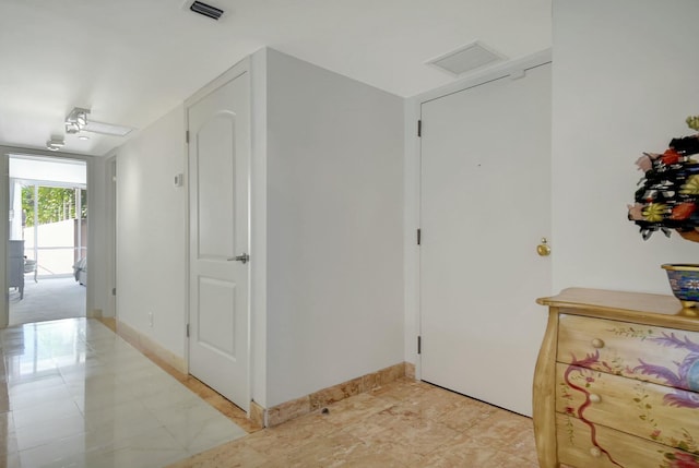 hallway featuring visible vents and baseboards