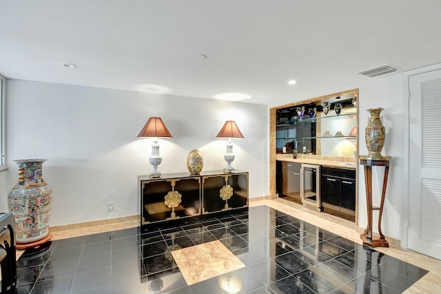 interior space featuring a dry bar, visible vents, baseboards, wine cooler, and dark tile patterned floors