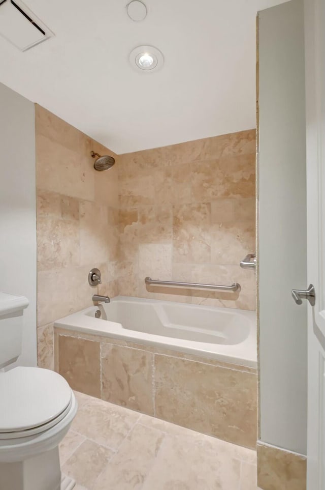 full bath with tile patterned flooring, tiled shower / bath combo, tile walls, and toilet