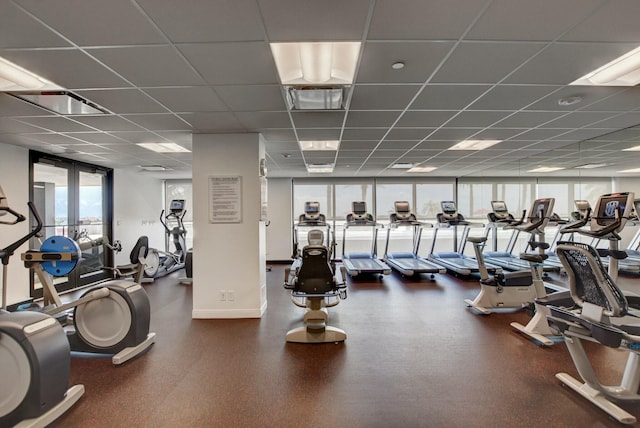 exercise room featuring expansive windows, french doors, and a paneled ceiling