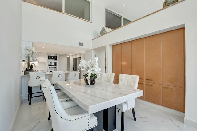 dining room with recessed lighting, a high ceiling, visible vents, baseboards, and marble finish floor