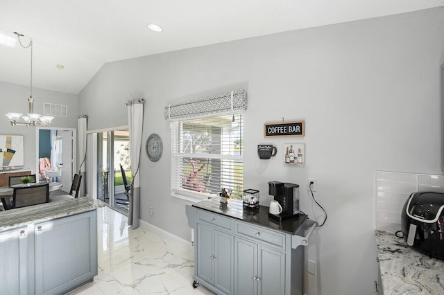 kitchen featuring a notable chandelier, a healthy amount of sunlight, hanging light fixtures, and vaulted ceiling