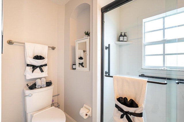 bathroom with plenty of natural light and toilet