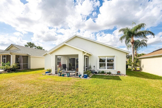 rear view of house featuring a sunroom and a yard